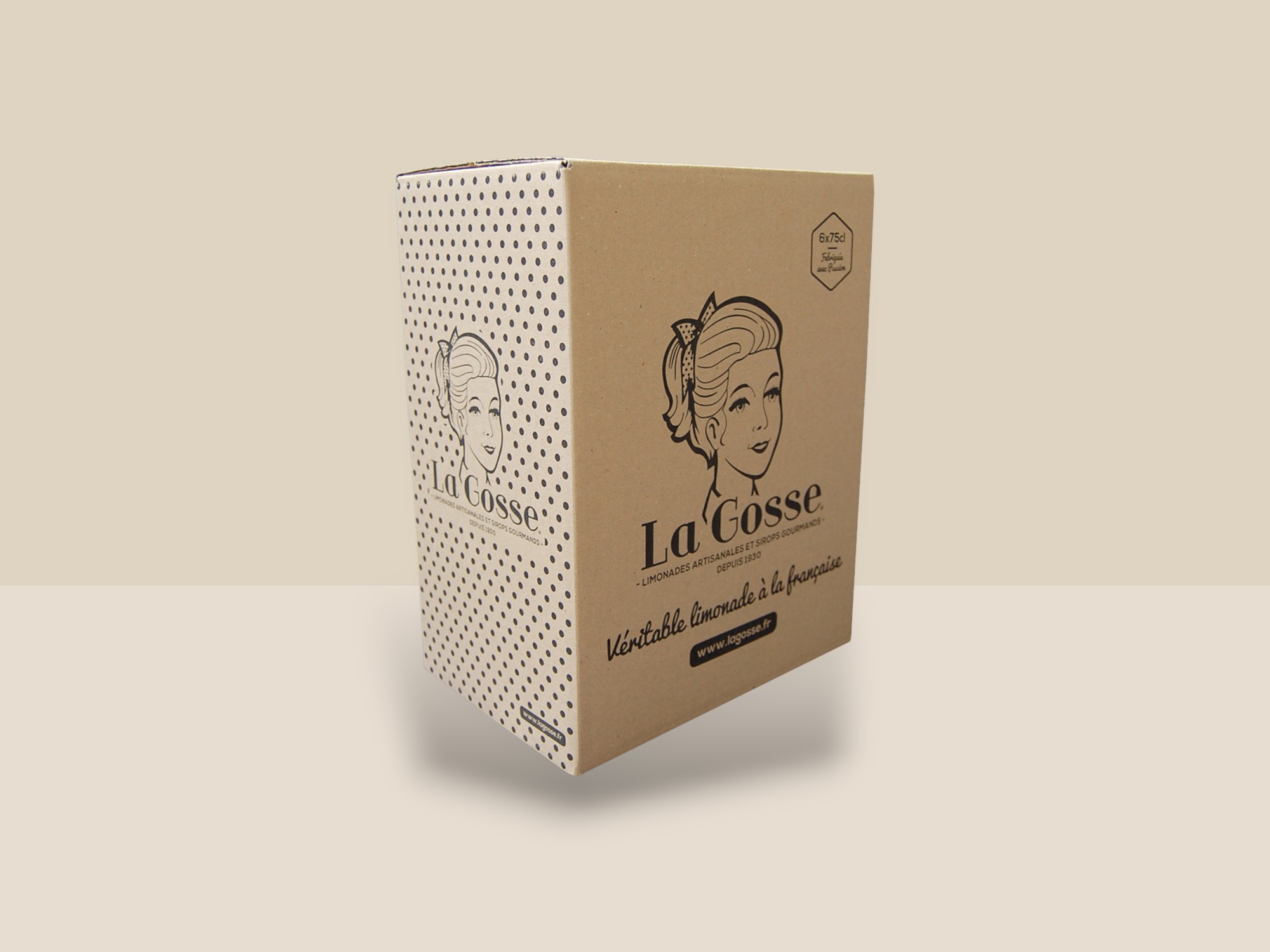 Une caisse couleur kraft et des points noirs. Il y a un logo d’une fille avec écrit La Gosse, véritable limonade à la française.