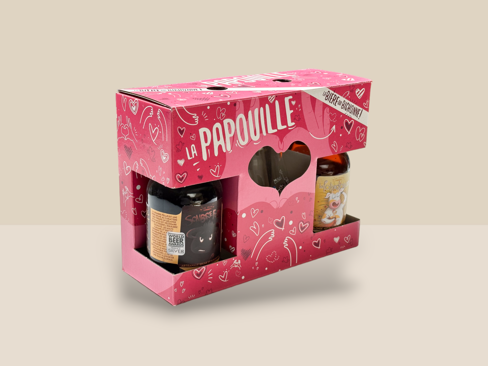 Une boîte rose contenant deux bouteilles de bière, présentée de manière élégante et attrayante. L’inscription La Papouille est présente en blanc et assez grand. Le design inclut des cœurs et des mains.