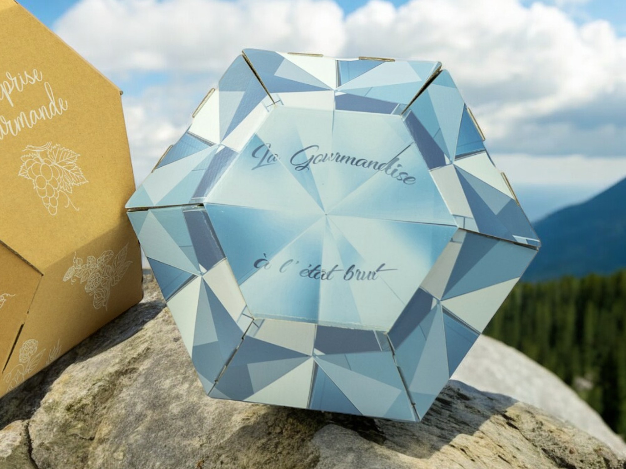 Packaging pour contenir des bouteilles de bière. Le coffret est en forme de diamant de couleur bleu avec des reflets et l'inscription la gourmandise à l'état brut.
